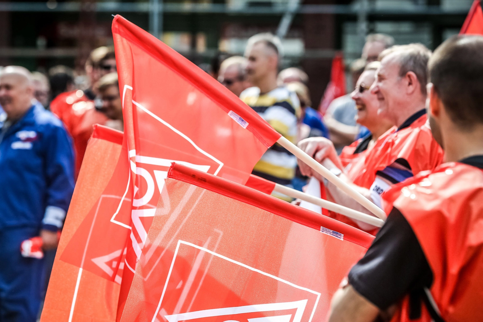 Eine Reihe Männer hält IG Metall-Fahnen.